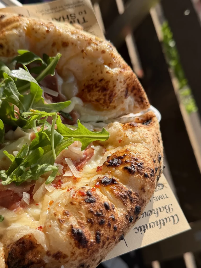 Neapolitanische Pizza mit luftigem, dunkel gebackenem Rand und frischem Rucola bei der Kunstspur Wennigsen