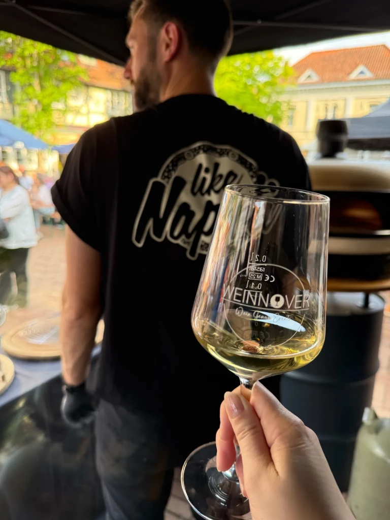 Weinglas vor dem Like-Napoli-Shirt des Pizzabäckers am Stand der Weinwanderung Gehrden